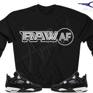 Puede incluir: Sudadera negra con el texto "RAW AF" en letras blancas y grises. La sudadera se combina con zapatillas negras y blancas.