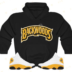 May include: Black hoodie with the text "Backwoods" in yellow and white lettering. A pair of white and yellow sneakers with black accents.