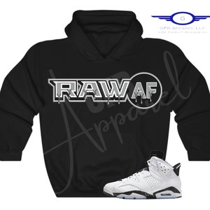 May include: Black hoodie with a white graphic that says "RAW AF" and a white and black trainer.