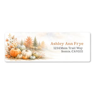 May include: A rectangular address label featuring a watercolor illustration of orange, white, and green pumpkins with autumn foliage and trees. The text reads: Ashley Ann Frye, 1234 Main Trail Way, Somis, CA 93111, printed in a dark serif font.