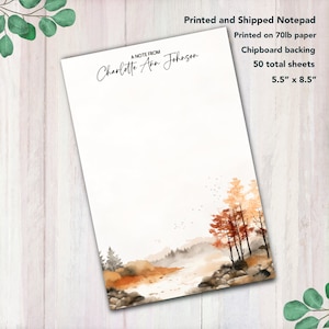 May include: A personalized notepad with a watercolor illustration of a forest scene with a river. The notepad is printed on 70lb paper with a chipboard backing and has 50 sheets. The notepad measures 5.5 inches by 8.5 inches. The text "A NOTE FROM Charlotte Ann Johnson" is printed at the top of the notepad.