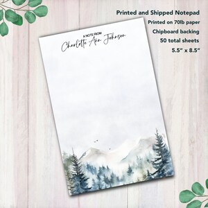 May include: A white notepad with a watercolor mountain scene. The notepad has a personalized message that reads "A Note From Charlotte Ann Johnson". The notepad is 5.5 inches by 8.5 inches and has 50 sheets.