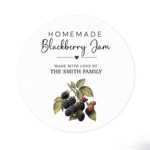 May include: A circular white label featuring the text HOMEMADE Blackberry Jam, a small heart icon, and the text MADE WITH LOVE BY THE SMITH FAMILY. Below the text is a detailed botanical illustration of a cluster of dark blackberries and green leaves.