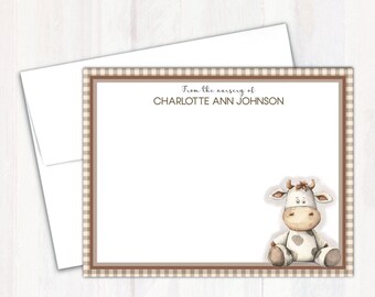 May include: A brown and white gingham border surrounds a white card with the text "From the nursery of CHARLOTTE ANN JOHNSON" at the top. A cartoon cow with brown spots sits in the bottom right corner of the card.