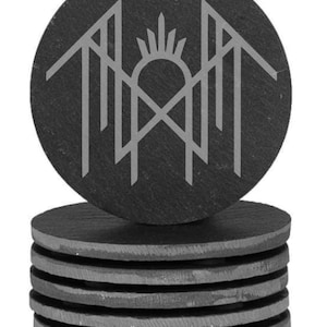 A stack of gray coasters with a circular design featuring a stylized bird or bird-like figure on top of it.