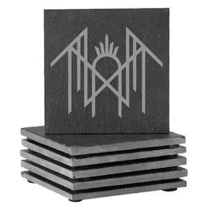 A stack of gray slate coasters with a stylized graphic design on them.