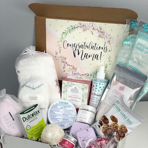 May include: A postpartum care gift box containing Earth Mama Milkmaid Tea, PeriFresh perineal cleanser, Tucks pads, Dulcolax laxative, Milkmakers lactation cookie bites, lavender bath salts, body butter, nipple butter, bath bombs, and underwear.