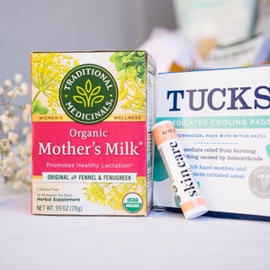 May include: A pink and green box of organic Mother's Milk tea, a blue and green box of Tucks Medicated Cooling Pads, and a small orange tube of skin care balm.