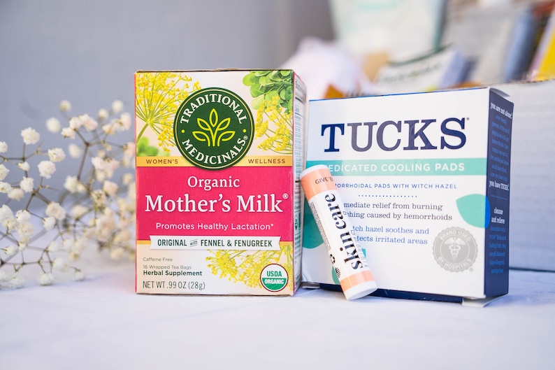 May include: A pink and green box of organic Mother's Milk tea, a blue and green box of Tucks Medicated Cooling Pads, and a small orange tube of skin care balm.