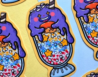 May include: A sticker featuring a cartoon milkshake with a purple, smiling face, orange donut, and star-shaped sprinkles. The milkshake is in a clear glass with a blue base and a striped straw.