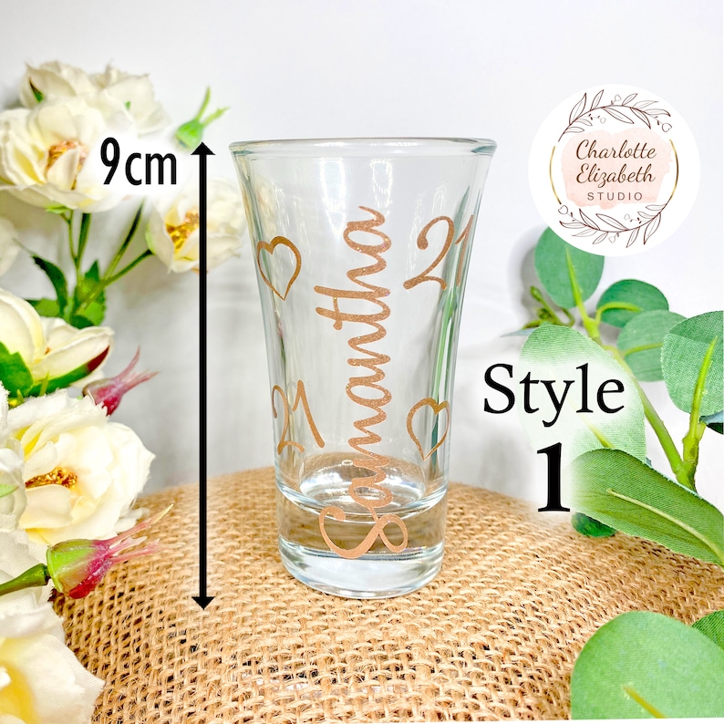 Op de afbeelding: Een helder glazen shotglas met een gouden ontwerp met de tekst "Samantha 21" en hartjes rond het ontwerp. Het shotglas is 9 cm hoog.
