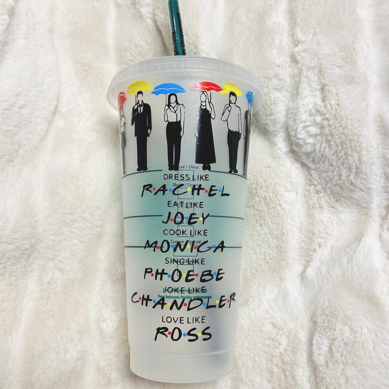 May include: A clear plastic tumbler with a black and white design featuring the characters from the TV show Friends. The tumbler has the text "Dress like Rachel, Eat like Joey, Cook like Monica, Sing like Phoebe, Joke like Chandler, Love like Ross" printed on it.