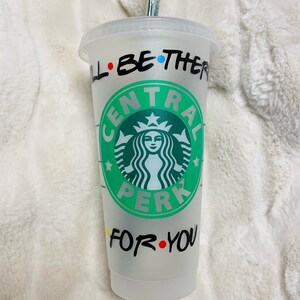 May include: A clear plastic tumbler with a green and white Starbucks logo that says "Central Perk". The tumbler has the text "I'll be there for you" written around the logo in black marker with colorful dots.