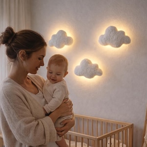 Peut inclure: Une chambre d'enfant avec un lit en bois, des lampes murales en forme de nuage et un bébé tenu dans les bras. La pièce a une palette de couleurs neutres, créant une atmosphère douce. Les lumières en forme de nuage ajoutent une touche fantaisiste.