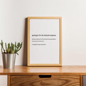 May include: A framed print with a white background and black text. The text reads "apologies for the delayed response [uh-paw-luh-jeez for the di-leyd-res-pons] phrase I completely forgot about this."