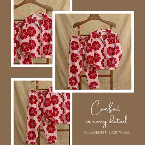 May include: A set of red floral print pajamas, including a button-down shirt and pants, displayed on wooden hangers. The pajamas have a light pink background with a repeating red flower pattern. The text "Comfort in every detail" is visible.