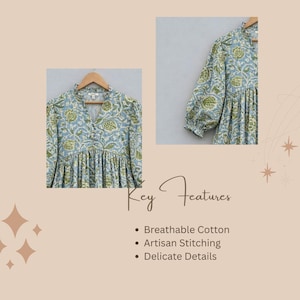May include: A light blue blouse featuring a green floral block print pattern, a V-neckline with a button-down front, and long sleeves with gathered cuffs. The garment has a relaxed, pleated bodice and is displayed on a wooden hanger.