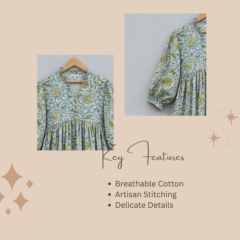 May include: A light blue blouse featuring a green floral block print pattern, a V-neckline with a button-down front, and long sleeves with gathered cuffs. The garment has a relaxed, pleated bodice and is displayed on a wooden hanger.