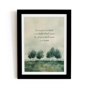 Op de afbeelding: Een ingelijst afdruk met een aquarel van een bos met een citaat over teamwork. Het citaat luidt: "De kracht van het team is elk individueel lid. De kracht van elk lid is het team."