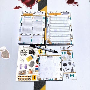 May include: A collection of forensic-themed notepads and a pen. The notepads feature designs with skulls, DNA strands, and crime scene elements. The pen has the number "2" printed on it. The notepads include "Daily Plan", "To Do List", and "Notes".