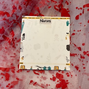 May include: A white notepad with a yellow and black crime scene tape border. The notepad has a white background with a variety of crime scene related illustrations, including a skull and crossbones, a magnifying glass, a pair of gloves, and a DNA strand. The notepad has the word "Notes" written in black marker at the top.