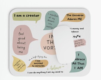 May include: A motivational affirmation desk mat with colorful speech bubbles and text that reads "I am a creator", "I feel good about being me", "I manifest all my dreams into reality", "I am entitled to miracles", "I can do anything I set my mind to", "In the vortex", "The Universe Adores Me", "I embrace all that I am", "Everything that I want is on its way", "I believe", "I attract money and abundance", "You body carrying me through my days".