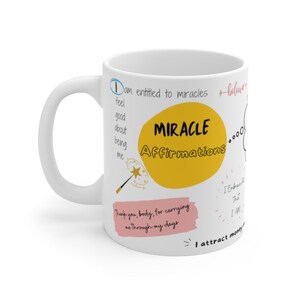 以下が含まれることがあります： 白いセラミック製のマグカップで、黄色の円の中に黒い文字で「MIRACLE Affirmations」と書かれています。マグカップには、ピンクと白の文字で、「私は奇跡を受ける資格がある」や「私の日々を支えてくれてありがとう、体」などの肯定的な言葉が書かれています。