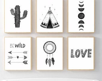 May include: Six framed black and white art prints with a bohemian theme. The prints feature a cactus, teepee, moon phases, the words "BE WILD" with arrows, a dreamcatcher, and the word "LOVE". The art is displayed on a white wall.