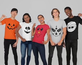 May include: Five people wearing Halloween themed t-shirts. The shirts feature a pumpkin, a ghost, a jack-o'-lantern, a skull, and a mummy.