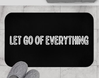May include: Black bath mat with white text that reads "LET GO OF EVERYTHING".