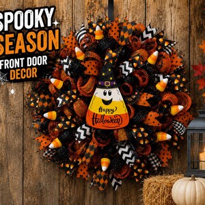 May include: A Halloween wreath with orange, black, and white ribbons, candy corn accents, and a candy corn-shaped sign that says "Happy Halloween." The wreath is decorated with a witch hat and the words "Spooky Season Front Door Decor."