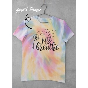 K&ouml;nnte beinhalten: Batik-T-Shirt mit einem L&ouml;wenzahn und dem Text "just breathe" in Schwarz.