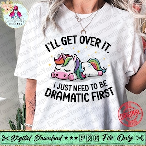 May include: White t-shirt with the text "I'll get over it. I just need to be dramatic first." A cartoon unicorn with a rainbow mane and tail is lying down. The shirt also has a design that says "Original Design".