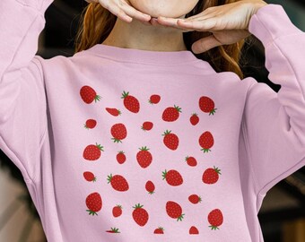 Peut inclure: Un sweat-shirt rose avec un motif de fraises rouges.