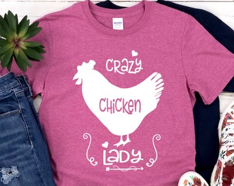 May include: A pink t-shirt with a white silhouette of a chicken and the text "crazy chicken lady".