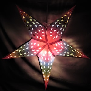 May include: A red, blue, and green paper star lantern with white stars. The lantern is lit from within, creating a warm glow.