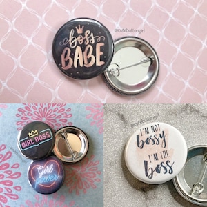 Może przedstawiać: Cztery różne guziki z motywacyjnymi cytatami. Pierwszy guzik jest czarny z złotymi literami i napisany jest "boss babe". Drugi guzik jest czarny z białymi literami i napisany jest "girl boss". Trzeci guzik jest czarny z różowymi i żółtymi literami i napisany jest "girl power". Czwarty guzik jest biały z czarnymi literami i napisany jest "Nie jestem rozkazująca, jestem szefową".