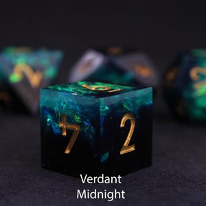 Beautiful black and blue / green resin dice sit on a black felt table top. Light shines down on the dice making the colours swirl into a maelstrom of epic colour. The dice include multicoloured foils that sparkle, shimmer and dance in the light.