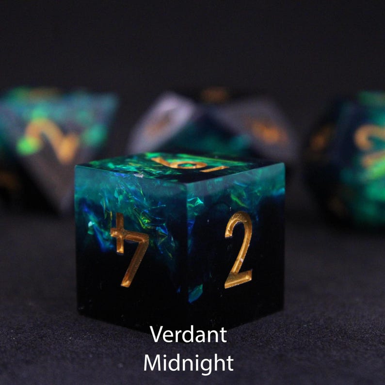 Beautiful black and blue / green resin dice sit on a black felt table top. Light shines down on the dice making the colours swirl into a maelstrom of epic colour. The dice include multicoloured foils that sparkle, shimmer and dance in the light.