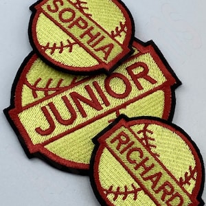Peut inclure: Trois patchs de softball brodés jaunes et rouges avec les noms "Sophia", "Junior" et "Richard" dessus.