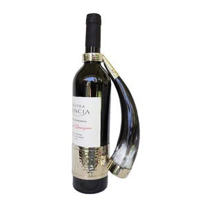 May include: A wine bottle with a silver band around the neck and a black and white horn handle. The bottle label reads "Nuestra Valencia" and "Vino Tinto".