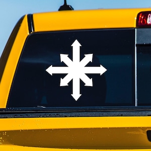 May include: A yellow pickup truck with a white sticker of a symbol with eight arrows pointing in different directions on the back window.