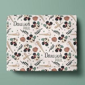 May include: White baby blanket with a repeating pattern of Mickey Mouse heads, baseball bats, and baseballs. The blanket has the names "Dawson Paul" printed on it.