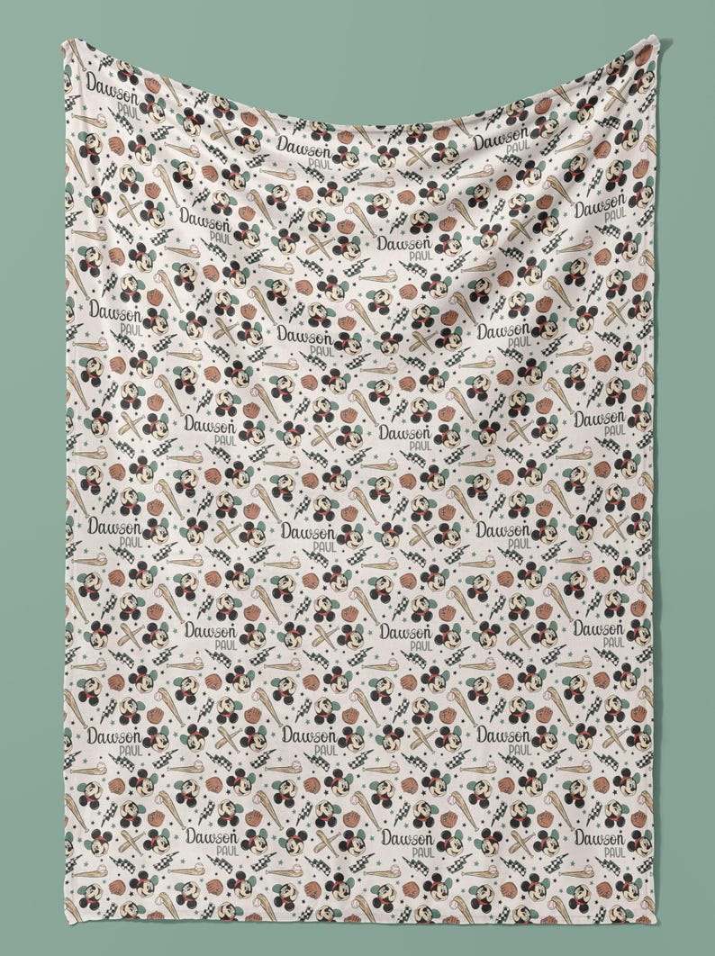 May include: A white baby blanket with a repeating pattern of Mickey Mouse, baseball bats, baseballs, and the name "Dawson Paul".
