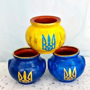 Des dessous de plat en terre cuite peints à la main, ornés d'un trident. Soutenez la décoration ukrainienne.
