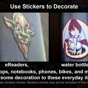 K&ouml;nnte beinhalten: Zwei bunte Aufkleber, einer mit einer gr&uuml;nen Goblin-&auml;hnlichen Kreatur und der andere mit einer wei&szlig;en Drachen-&auml;hnlichen Kreatur mit gelben Flammen. Der Text "Use Stickers to Decorate" befindet sich oben im Bild. Der Text "eReaders, laptops, notebooks, phones, bikes, and more. Add some decoration to these everyday items." befindet sich unten im Bild. Der Text "Example stickers shown. Stickers shown may not be included in this listing." befindet sich ganz unten im Bild.