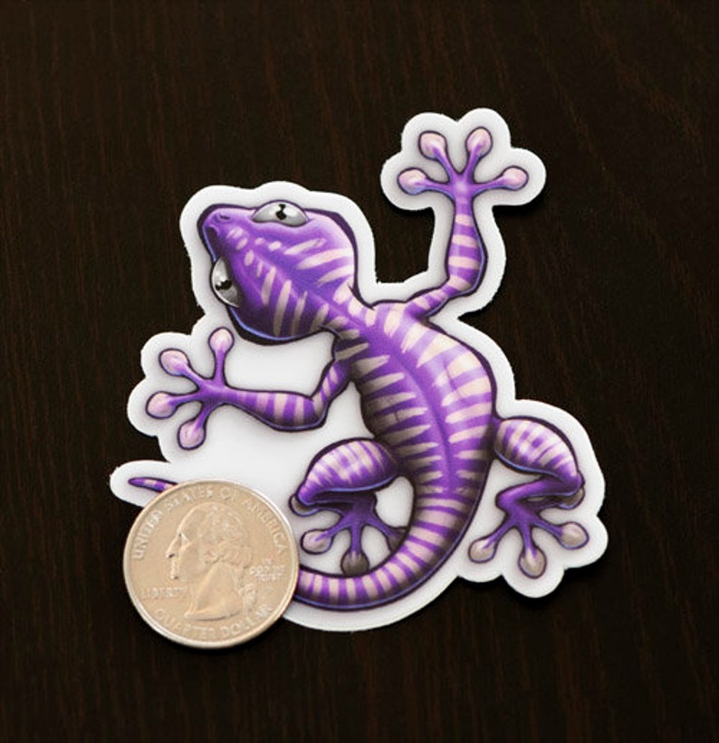 K&ouml;nnte beinhalten: Lilafarbener und wei&szlig;er Gecko-Aufkleber mit einem gestreiften Muster. Der Gecko befindet sich in einer Kletterpose mit eingerolltem Schwanz.