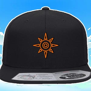 Puede incluir: Gorra de béisbol negra con un símbolo de sol bordado en naranja, con un círculo en el centro. La gorra tiene una visera curvada y un cierre a presión.