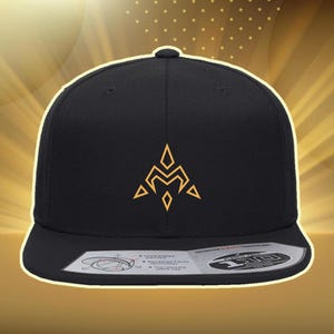 May include: Black snapback hat with a gold geometric design on the front. The hat has a flat brim and a structured crown. The design is a stylized letter "M" with arrow and diamond shapes. The hat is a classic, casual accessory.