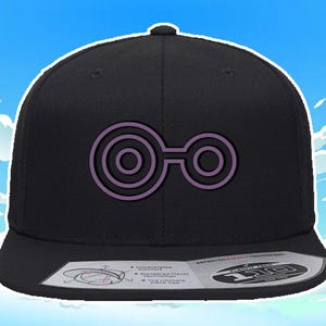 May include: Black fitted baseball cap with a purple Digimon symbol on the front. The symbol is a stylized eye with three concentric circles.